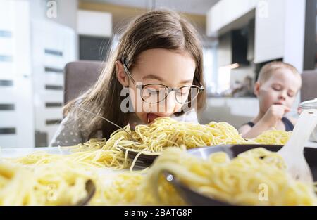 Portrait of a little, cute girl eating a spaghetti pasta Stock Photo