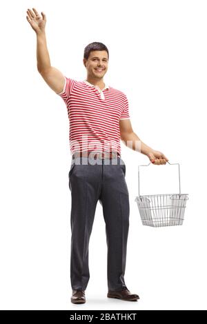 Full length portrait of a young man waving and carrying  a shopping basket isolated on white background Stock Photo