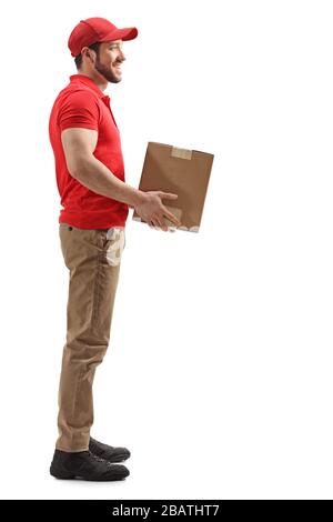 Full length profile shot of a delivery man holding a box isolated on white background Stock Photo