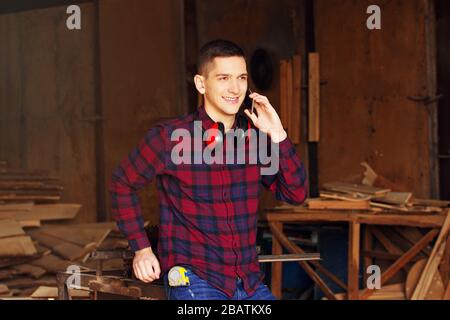 Workman at the sawmill. Young hardworking man Stock Photo
