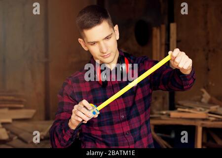 Workman at the sawmill. Young hardworking man Stock Photo