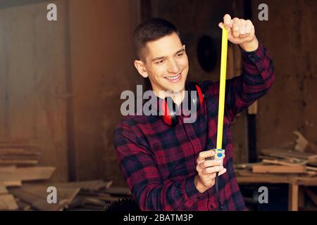 Workman at the sawmill. Young hardworking man Stock Photo