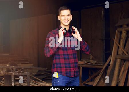 Workman at the sawmill. Young hardworking man Stock Photo
