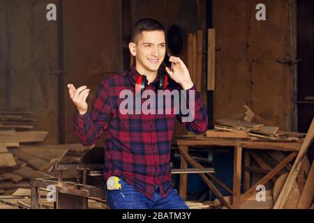 Workman at the sawmill. Young hardworking man Stock Photo