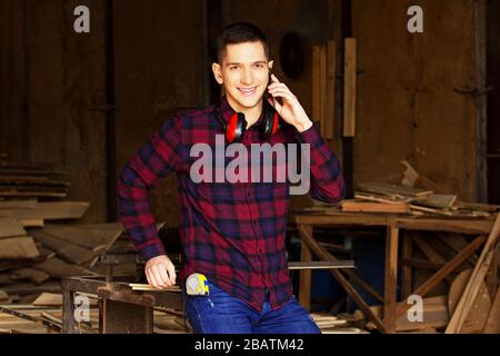 Workman at the sawmill. Young hardworking man Stock Photo