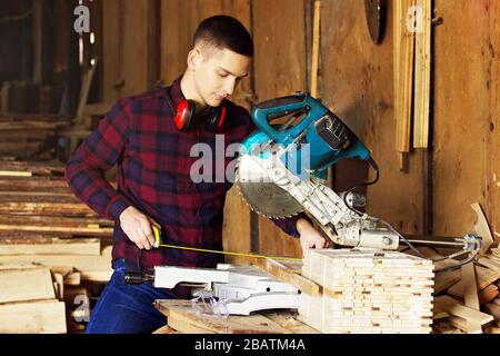 Workman at the sawmill. Young hardworking man Stock Photo