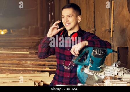 Workman at the sawmill. Young hardworking man Stock Photo