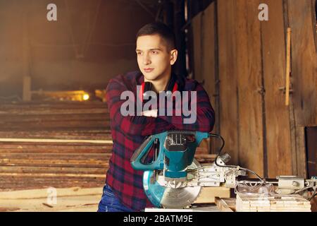Workman at the sawmill. Young hardworking man Stock Photo