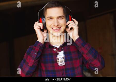 Workman at the sawmill. Young hardworking man Stock Photo