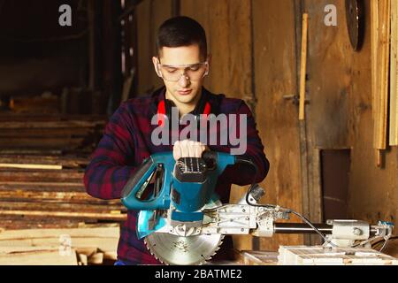 Workman at the sawmill. Young hardworking man Stock Photo