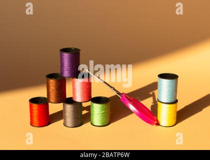 Creative composition with spools of colored threads and scissors. Sewing accessories, tailoring set. Stock Photo