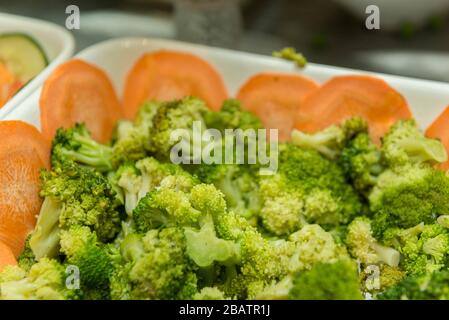 isolated dish of green salad, broccoli. Fresh, organic food for a healthy lifestyle, weight loss. Fresh raw sliced broccoli pieces closeup segments Stock Photo