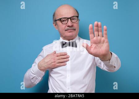 Senior businessman moving away hands palms showing refusal and denial gesture Stock Photo