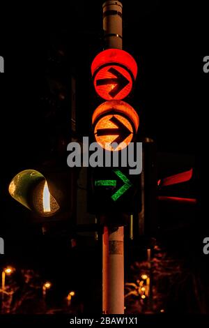 Closeup of colorful traffic lights with arrows in night city Stock Photo