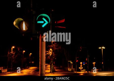 Closeup of colorful traffic lights with arrows in night city Stock Photo