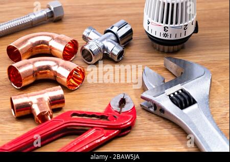 The photo shows different tools for sanitary installation on a wooden table Stock Photo