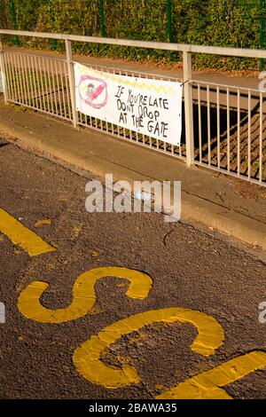 Banner painted by pupil, 'If you are late don't drop at the gate'. Parking/safety campaign.  Worsley Bridge Road Primary School, Beckenham, Kent, UK. Stock Photo