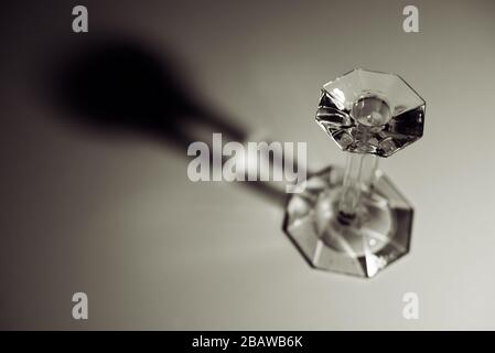 Glass candlestick casting shadow on white table. Concept : Minimalism in photography. Stock Photo