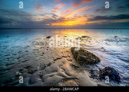 Swallow of the Wadden Sea in the Netherlands during sunset with wid angel view and colorful clouds. Stock Photo