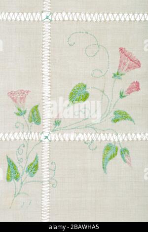 Ornament from embroidered flowers, cross-stitch on textile canvas, isolated on white background Stock Photo