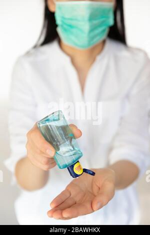 A women nurse sanitizing hands and preventing the spread of germs, bacteria and corona virus. Stock Photo