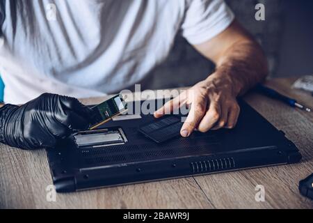 Technician installing new RAM module into the memory slot Stock Photo