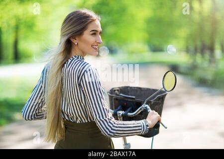 Attractive young woman with her bicycle in the city Stock Photo