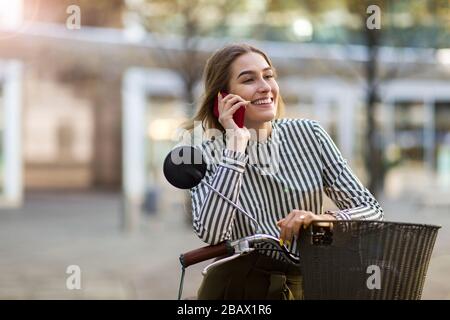 Attractive young woman with her bicycle in the city Stock Photo