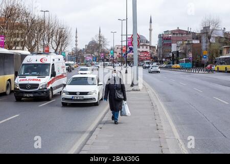 Single mid aged woman wearing a medical mask is walking near Eminonu district. Because of the new type of Coronavirus. Stock Photo