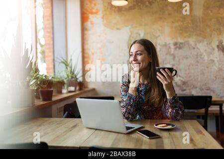 Young woman with laptop in cafe Stock Photo