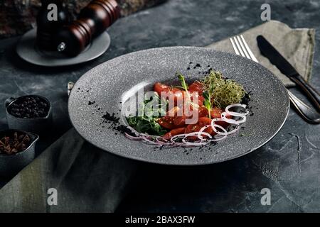 Tuna tagliata in vegetables stewed carrots and peppers, Beautiful serving, traditional Italian cuisine, gray background, copy space. food concept Stock Photo