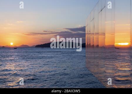 Dramatic Evening Sunset Sky over Andaman Sea Reflected in Glass Structure on Krabi Ao Nang Beach, Thailand Stock Photo