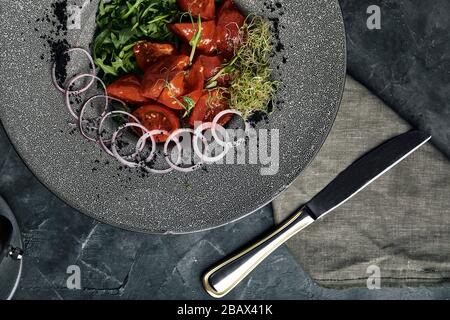 Tuna tagliata in vegetables stewed carrots and peppers, Beautiful serving, traditional Italian cuisine, gray background, copy space. food concept Stock Photo
