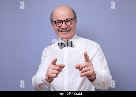 Handsome mature man in glasses pointing at camera pointing at you Stock Photo