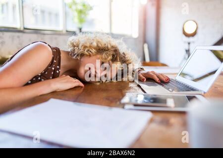 Young businesswoman asleep at her desk in an office Stock Photo