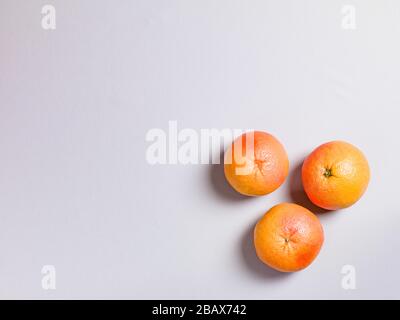 Three Fresh Oranges on Grey Background Stock Photo