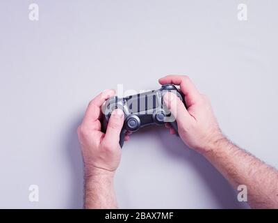 Hands Holding Game Controller on Grey Background Stock Photo