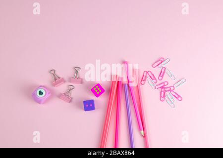 Multi-colored red and pinc pencils rulers, pens, pencils and scissors and stationery stand on a pink background Stock Photo