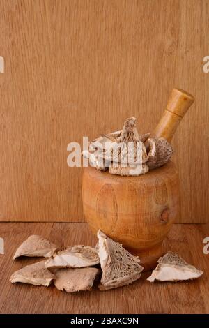 Dry Parasol mushroom or Macrolepiota procera in bamboo  mortar over wooden background, ready for the kitchen Stock Photo