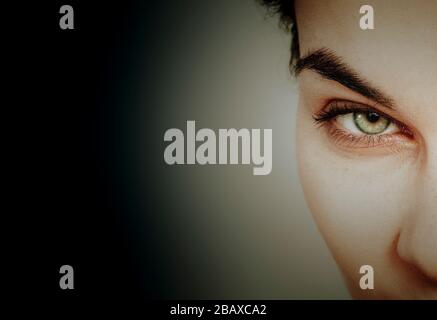 eyes spying concept  through hole against dark background Stock Photo