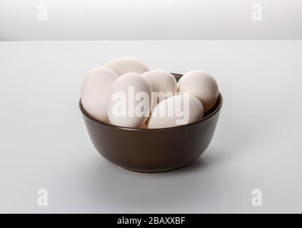 White chicken eggs in a plate on a white background. Stock Photo