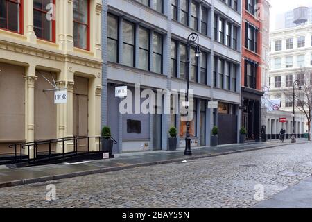 New York, NY, 29th March 2020. Closed and boarded up storefronts in the SoHo neighborhood of Manhattan. An executive order issued by New York State Governor Andrew Cuomo has closed non-essential businesses during the coronavirus COVID-19 pandemic. Most businesses have not boarded their storefronts with plywood, and those that have have done so out of fear of possible large scale vandalism and rioting. Credit: Robert K. Chin. Stock Photo