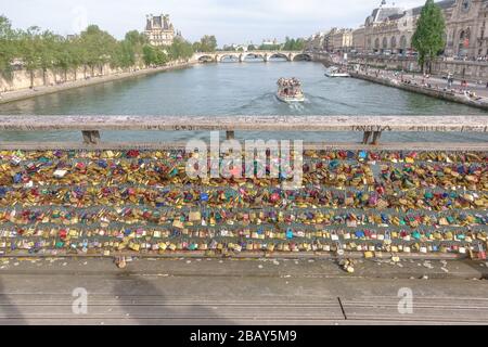Love locks on the Passerelle Léopold-Sédar-Senghor in Paris, France on a sunny day with the Pont Royal in the background Stock Photo