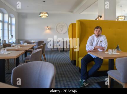 Cottbus, Germany. 25th Mar, 2020. Tim Sillack, chef and owner of the renovated Cavalierhaus in the Fürst-Pückler-Park Branitz, is sitting in his empty restaurant. For the planned opening on April 1, he and his kitchen team spent a week cooking up and down the menu for a trial period. But the opening is cancelled for the time being due to the Corona pandemic. (to dpa "60 kilos of wild boar leg in the freezer: the Cavalierhaus is only sleeping") Credit: Patrick Pleul/dpa-Zentralbild/ZB/dpa/Ģ����ý Live News Stock Photo