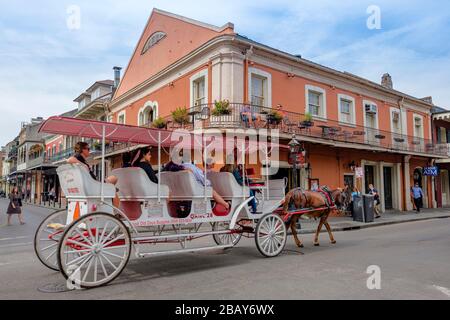 Tourists taking a horse drawn cart guided tour on streeet of old New Orleans French Quarter New Orleans, Louisiana, USA. Stock Photo