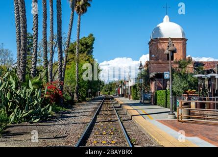 A single set of train tracks leads to a vanishing point on the horizon at the San Juan Capistrano train station. Stock Photo