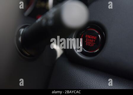 engine start stop with red light in a new technology car engine start stop button Stock Photo
