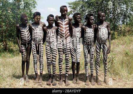 Group of Seven Mursi Tribe Boys with Body Paint all over lined up for a Photograph Stock Photo