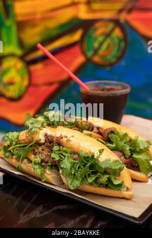 Vietnamese traditional sandwich, pork Banh-mi with black coffee. Two vietnamese foods on a tray. Stock Photo