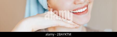 Close up shot of glad satisfied woman being happy after spa procedure, has fresh soft healthy skin, broad smile, white perfect teeth touch her face Stock Photo